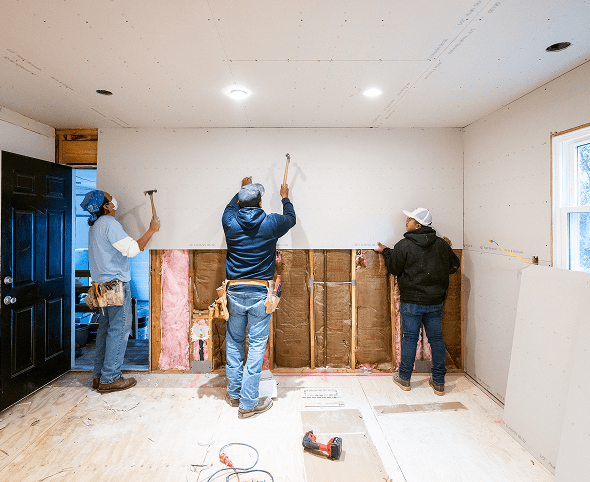 Construction team fixing walls indoors