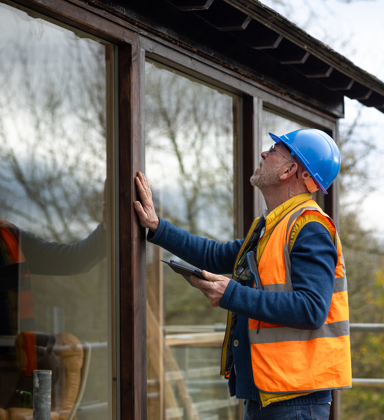 Construction worker inspecting a building window.